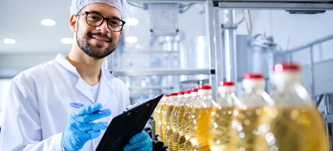 Trabajador verificando la producción de botellas de vinagre en una fabrica