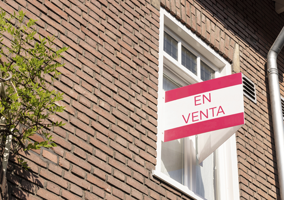 Cartel de venta en la ventana de un piso